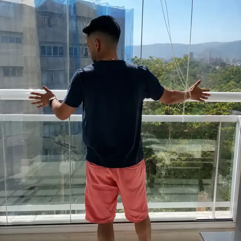Instalador conferindo os painéis de vidro de uma sacada envidraçada